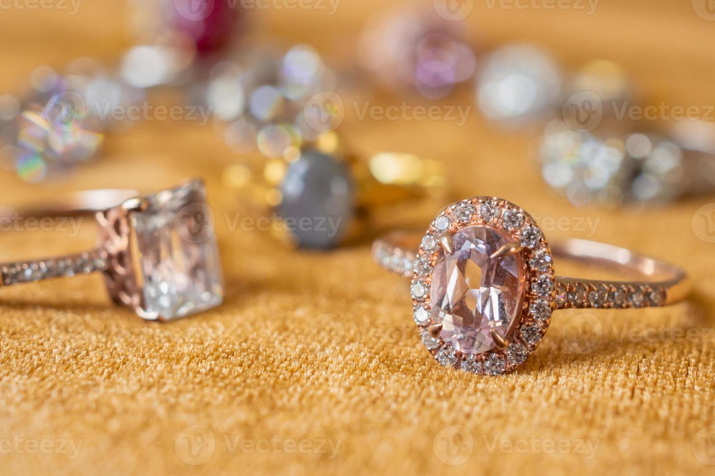 sieraden diamant ringen Aan gouden kleding stof achtergrond dichtbij omhoog foto