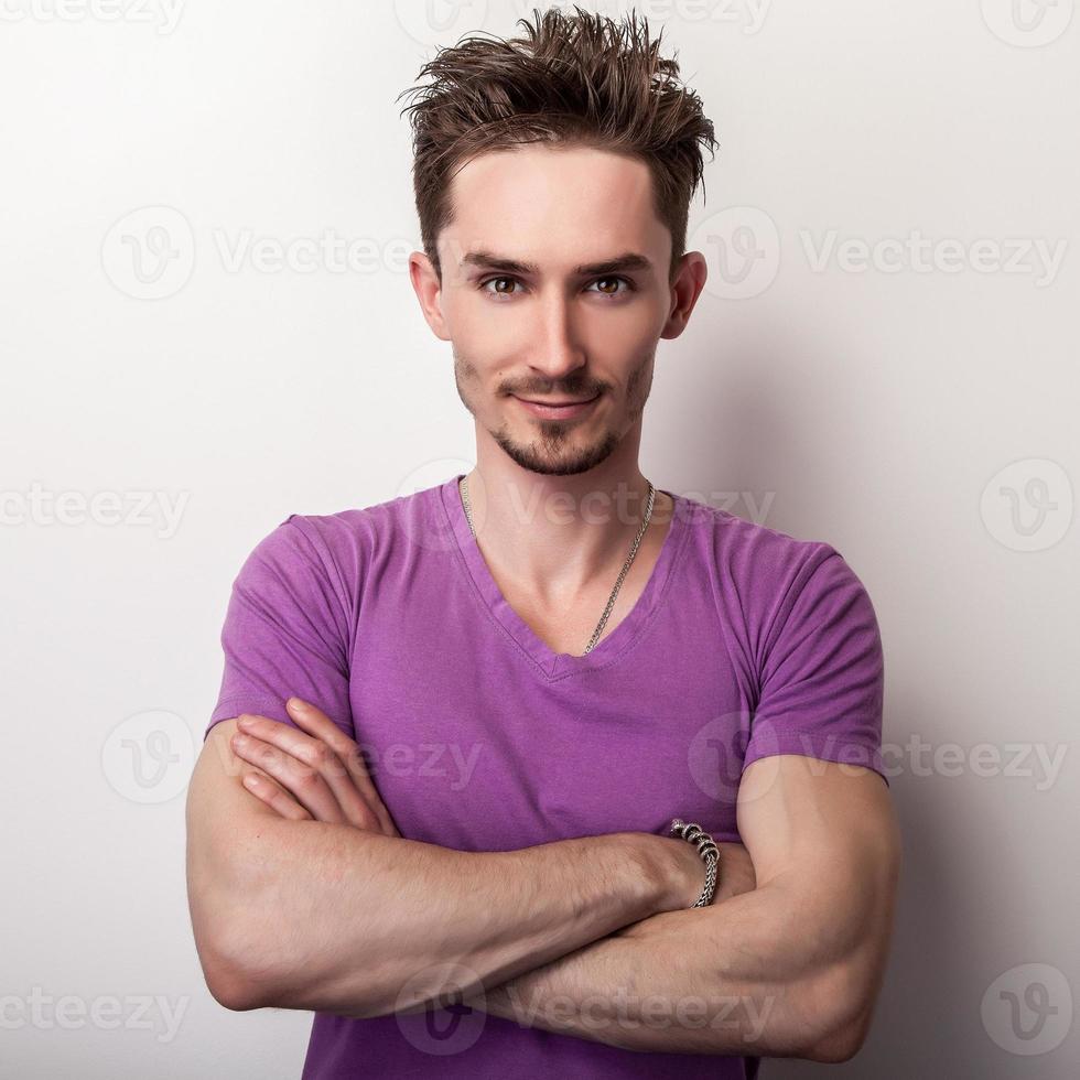 portret van de jonge knappe man in violet t-shirt. foto