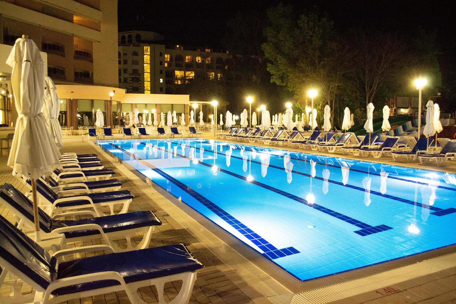 bulgarije, laguna park. 10.06.2022. avond zwembad in luxe hotel. zwembad met zon bedden en Gesloten paraplu's. foto