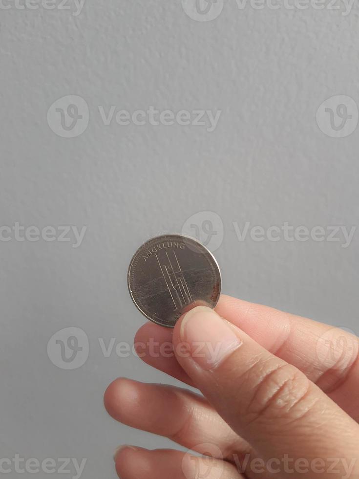 geïsoleerd foto van een hand- Holding een duizend roepia munt.