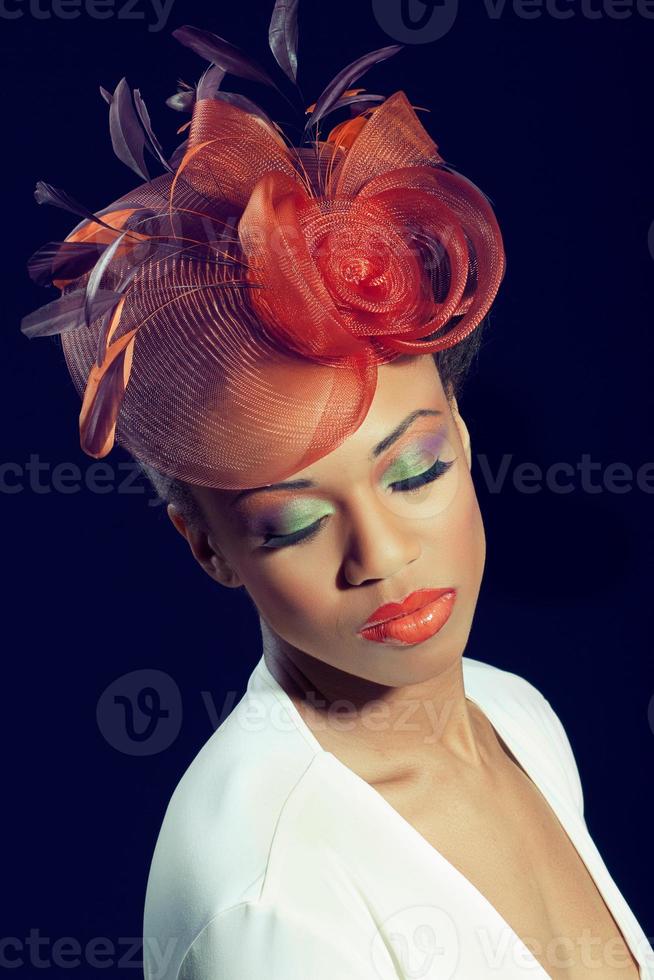 mooie jonge vrouw met kleurrijke make-up die een stijlvolle hoed draagt foto