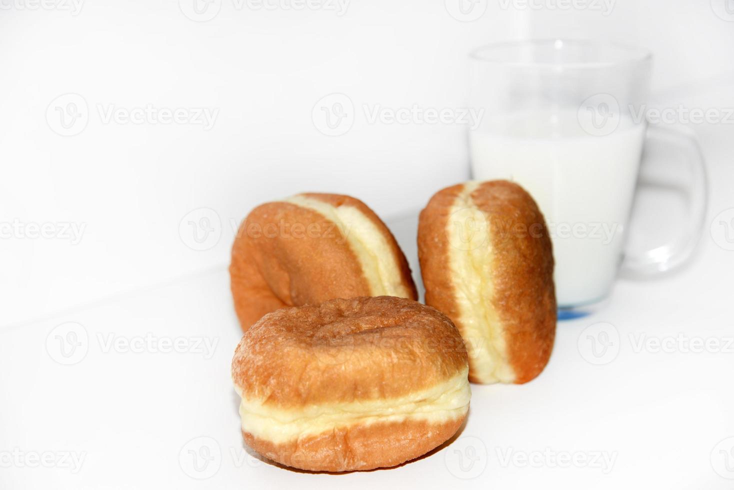 heerlijk zoet broodjes met jam en een glas van melk Aan een wit achtergrond. een heerlijk ontbijt van prachtig gebakken broodjes en melk. foto
