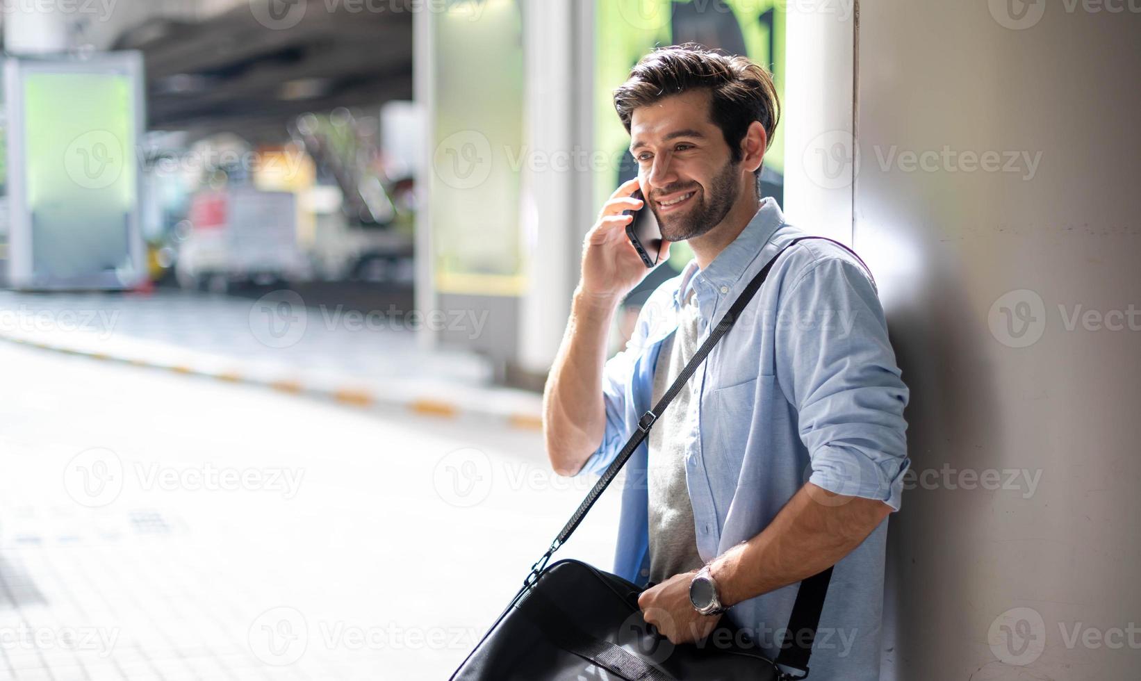 de bedrijf Mens pratend Aan slim telefoon Aan hun manier. gevoel gelukkig en ontspannend, gewoontjes jong zakenman vervelend pak jasje en schouder tas. foto