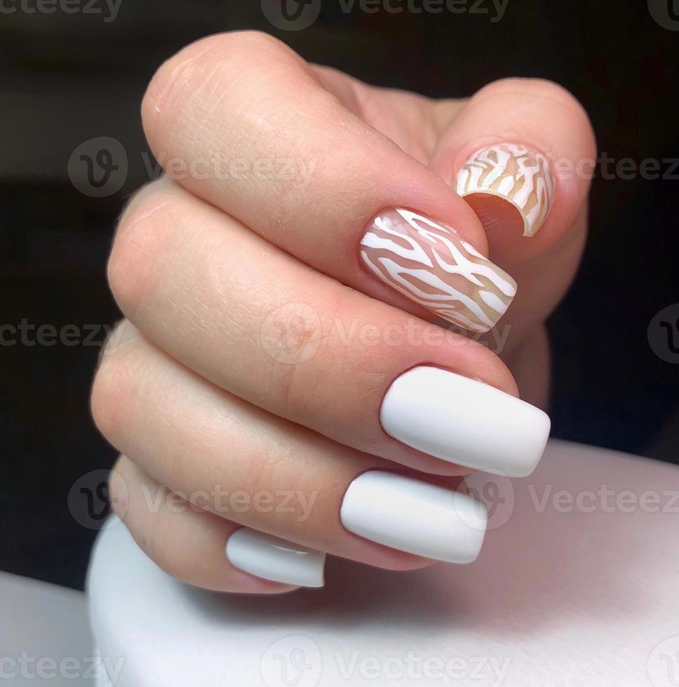elegant modieus vrouw wit manicure met ontwerp.handen van een vrouw met wit manicure Aan nagels foto