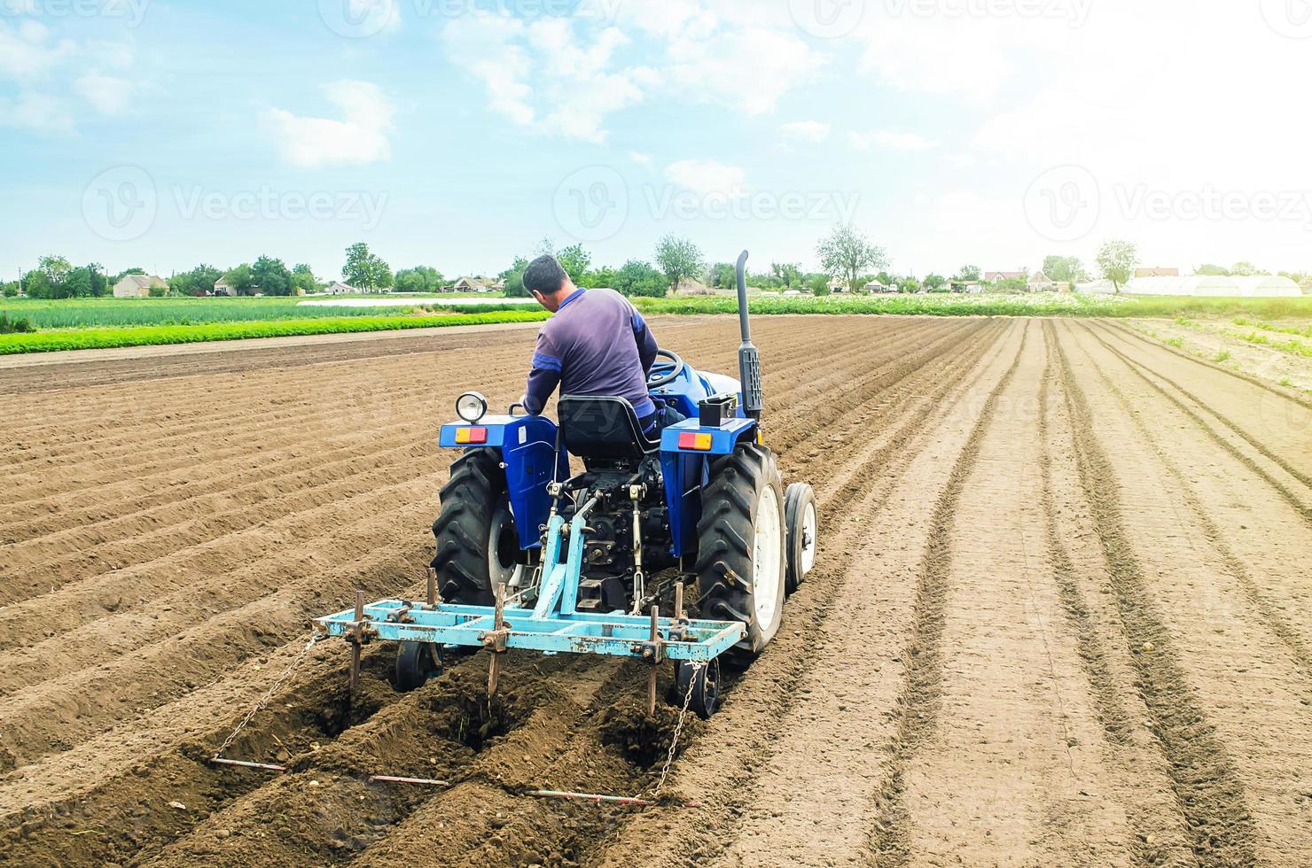 boer Aan een trekker maken rijen Aan een boerderij veld. voorbereidingen treffen de land- voor aanplant toekomst Bijsnijden planten. teelt van bodem voor planten. agro-industrie, landbouwbedrijf. landbouw, Europese landbouwgrond. foto