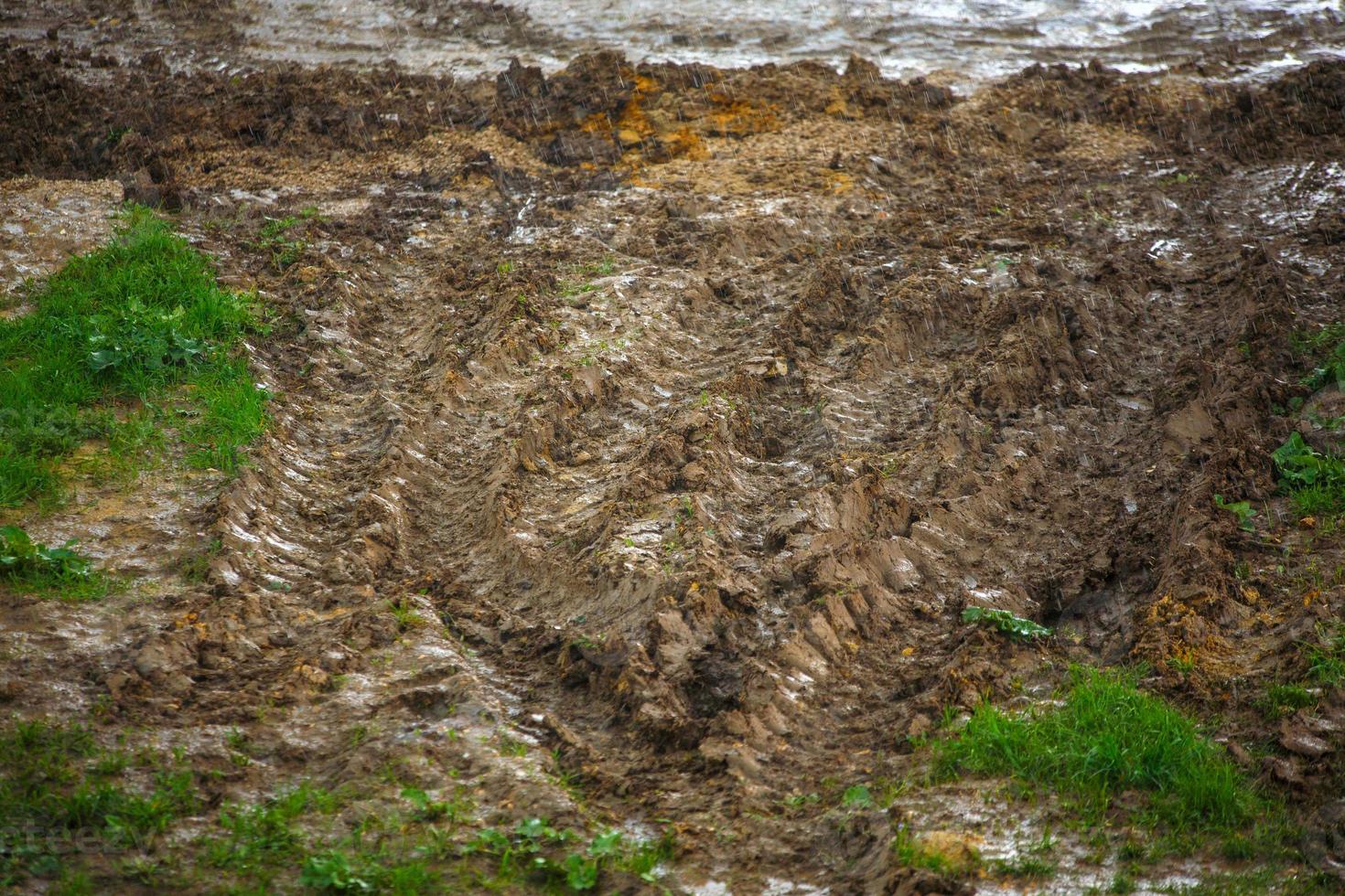 zwaar voertuig sporen Aan aarde oppervlakte onder zomer regen foto