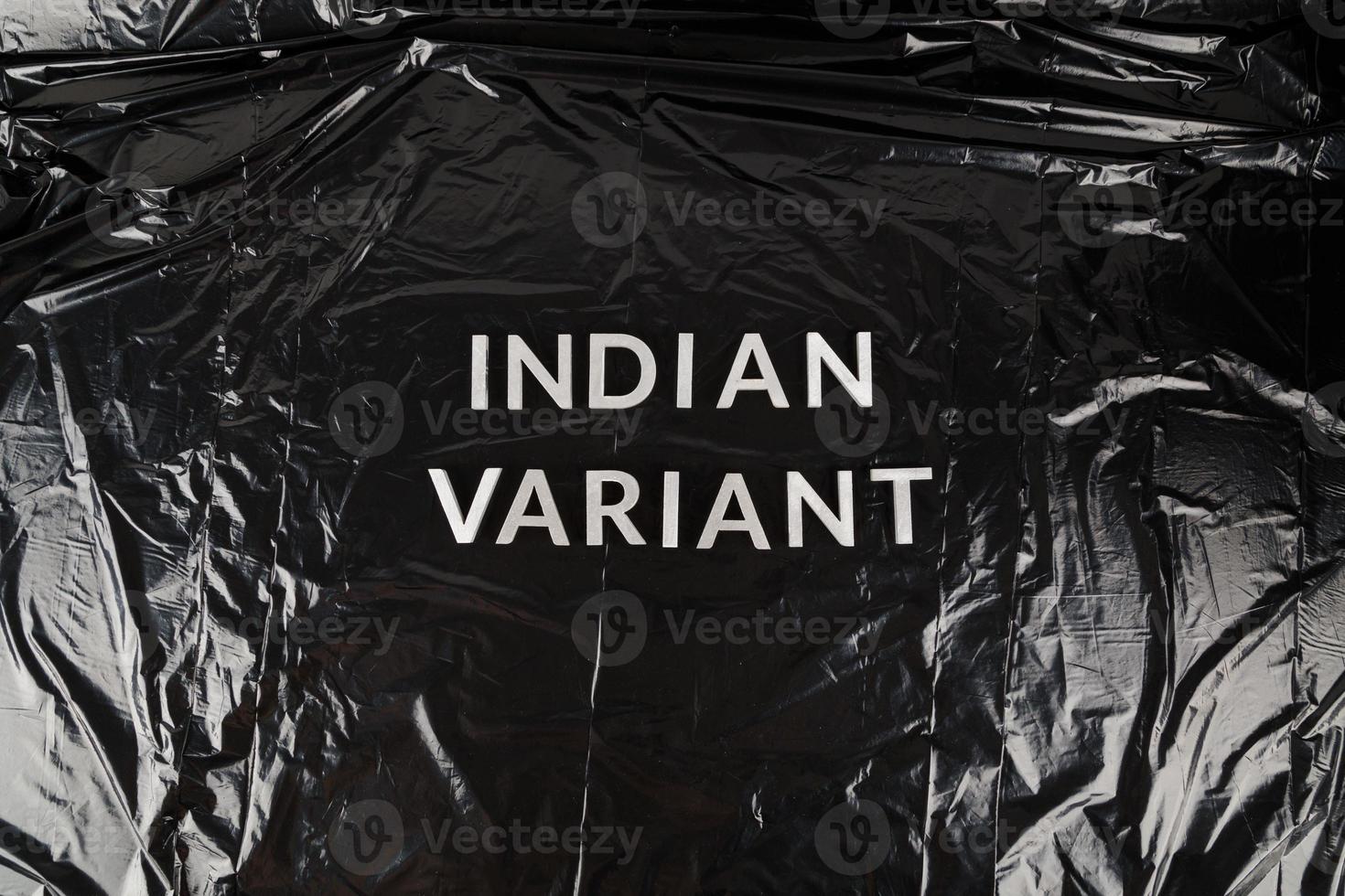 woorden Indisch variant gelegd met zilver metaal brieven Aan verfrommeld zwart plastic zak achtergrond foto