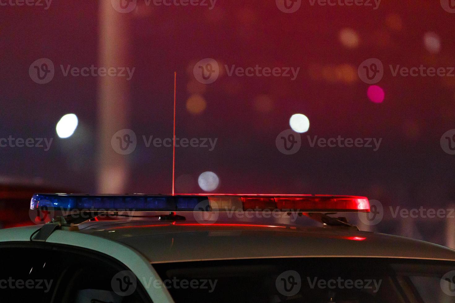 rood Politie auto licht Bij nacht in stad met selectief focus en bokeh Aan zwart achtergrond foto