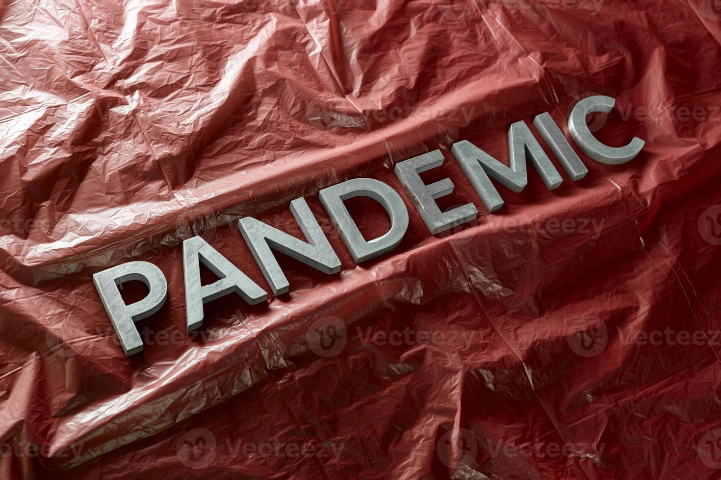 de woord pandemisch gelegd met zilver brieven Aan verfrommeld oranje plastic film - diagonaal perspectief samenstelling met selectief focus foto
