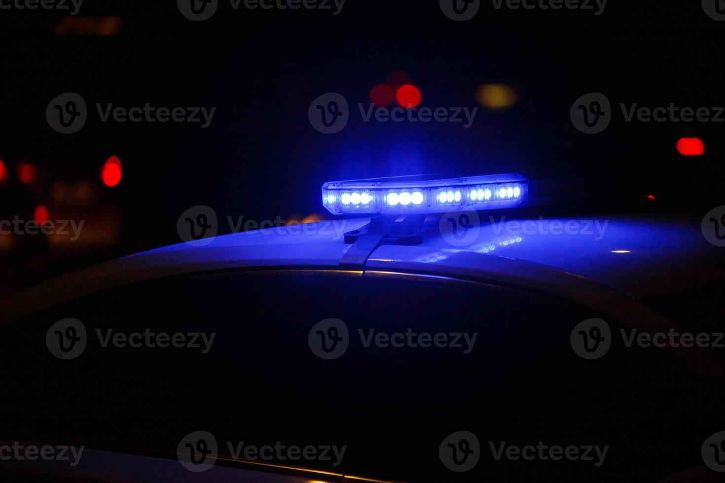 blauw Politie auto licht Bij nacht in stad met selectief focus en bokeh Aan zwart achtergrond foto