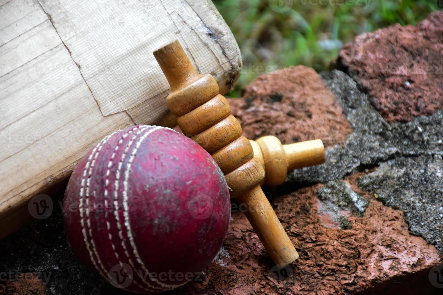 krekel sport uitrustingen Aan steen, knuppel, wicket, oud leer bal, zacht en selectief focus. foto