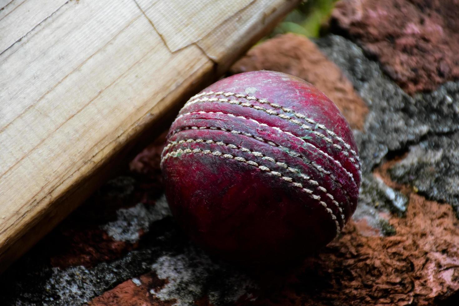 krekel sport uitrustingen Aan steen, knuppel, wicket, oud leer bal, zacht en selectief focus. foto