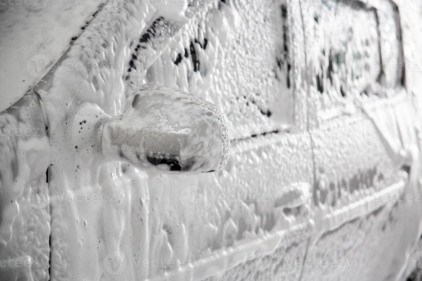 detailopname visie van motor auto met solide laag van zeep sud gedurende auto wassen. foto