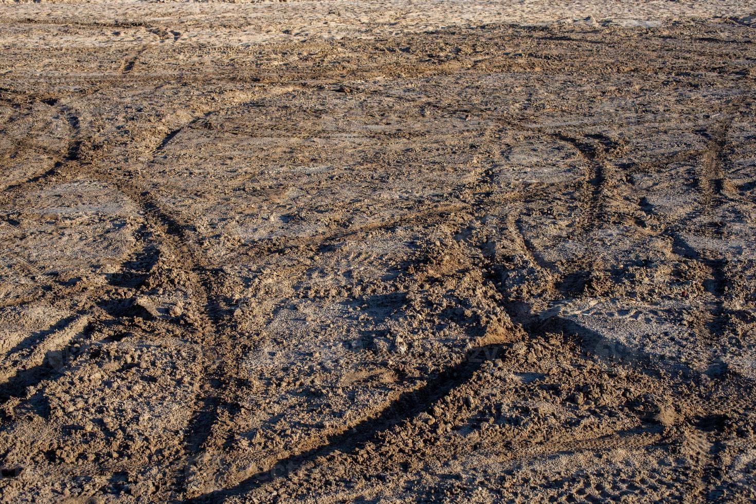 droog zand en modder grond met veel aarde fiets sporen Bij daglicht foto