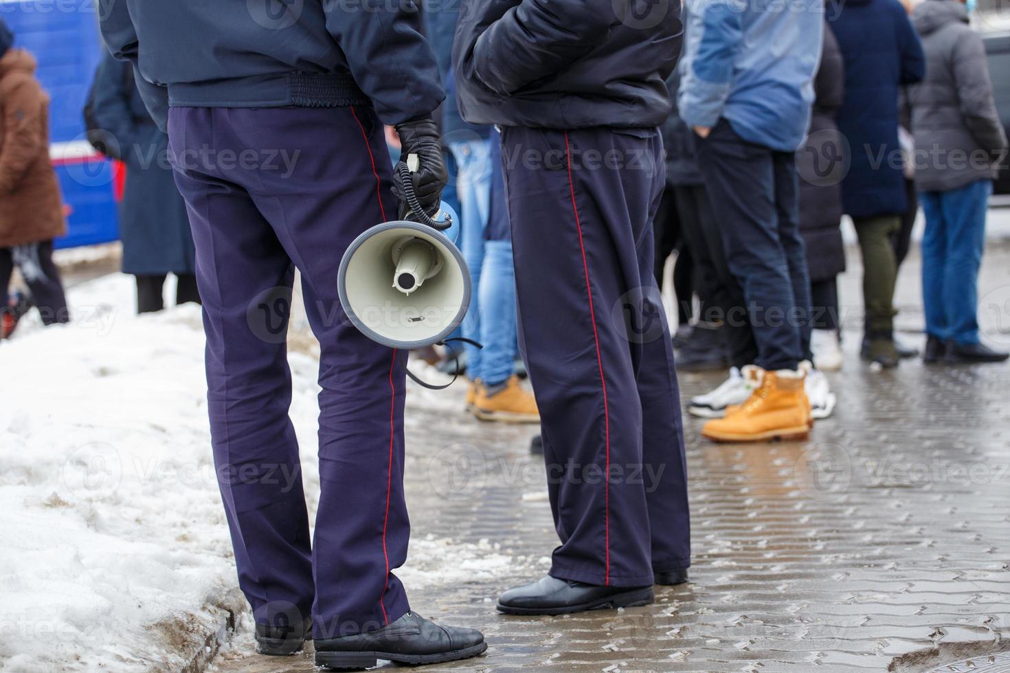 Politie officier Holding luidspreker megafoon buitenshuis, detailopname foto