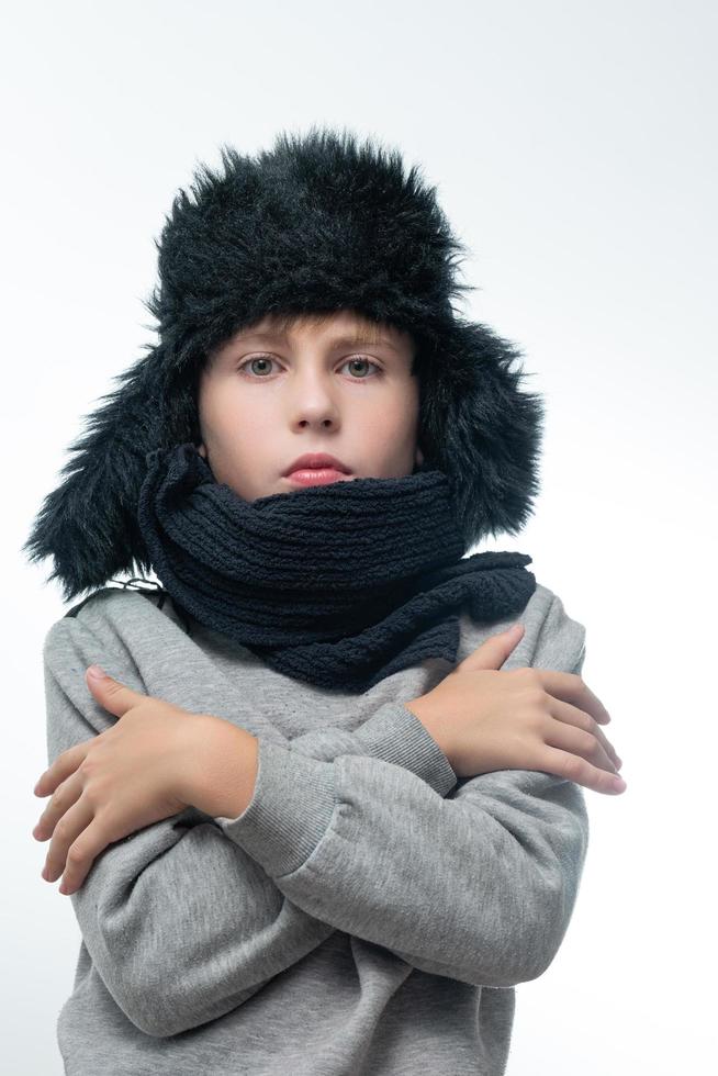 winter hoed met oorkleppen en sjaal, portret van een jongen in winter kleren. foto