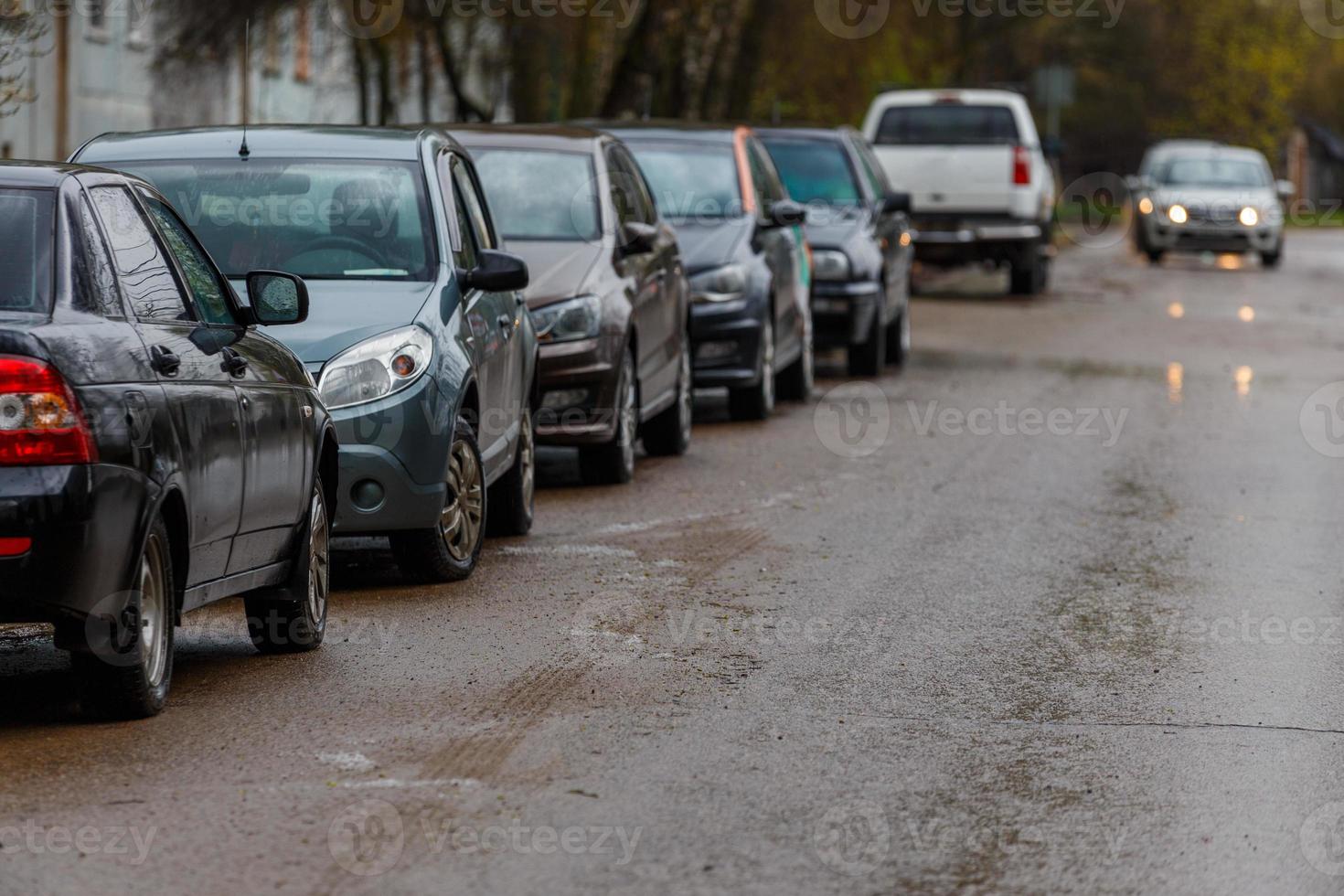 auto's geparkeerd Aan kant van nat vuil weg - telefoto detailopname met selectief focus foto