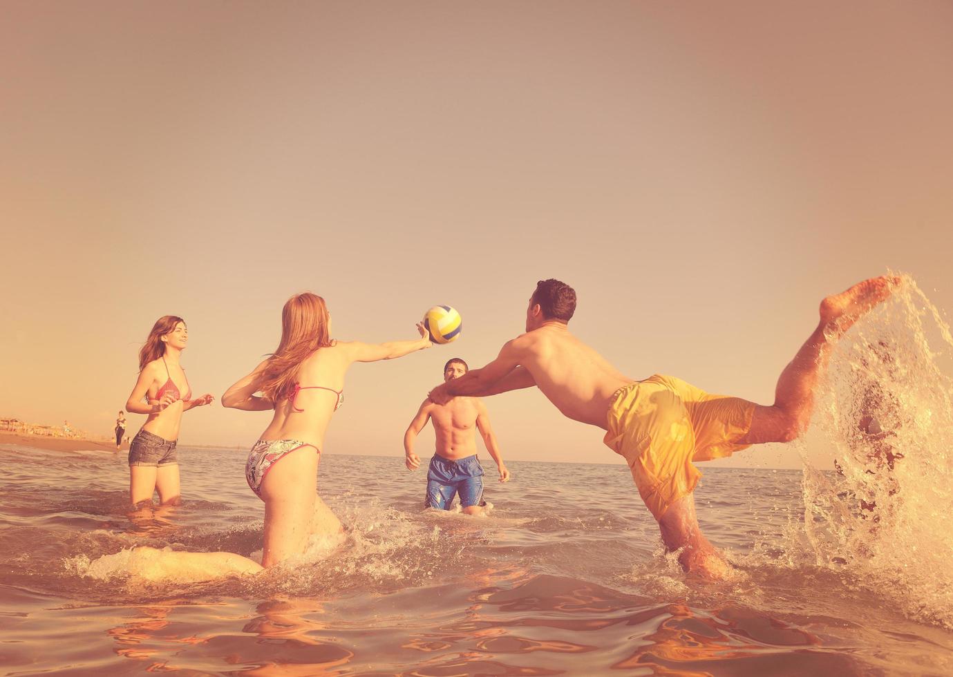 jong mensen groep hebben pret en Speel strand volleybal foto