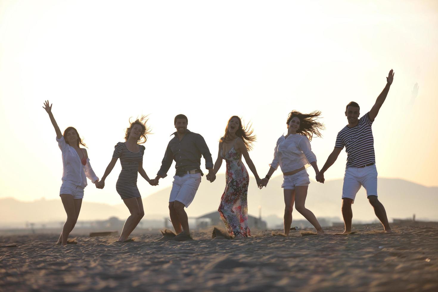 gelukkig jong mensen groep hebben pret Aan strand foto