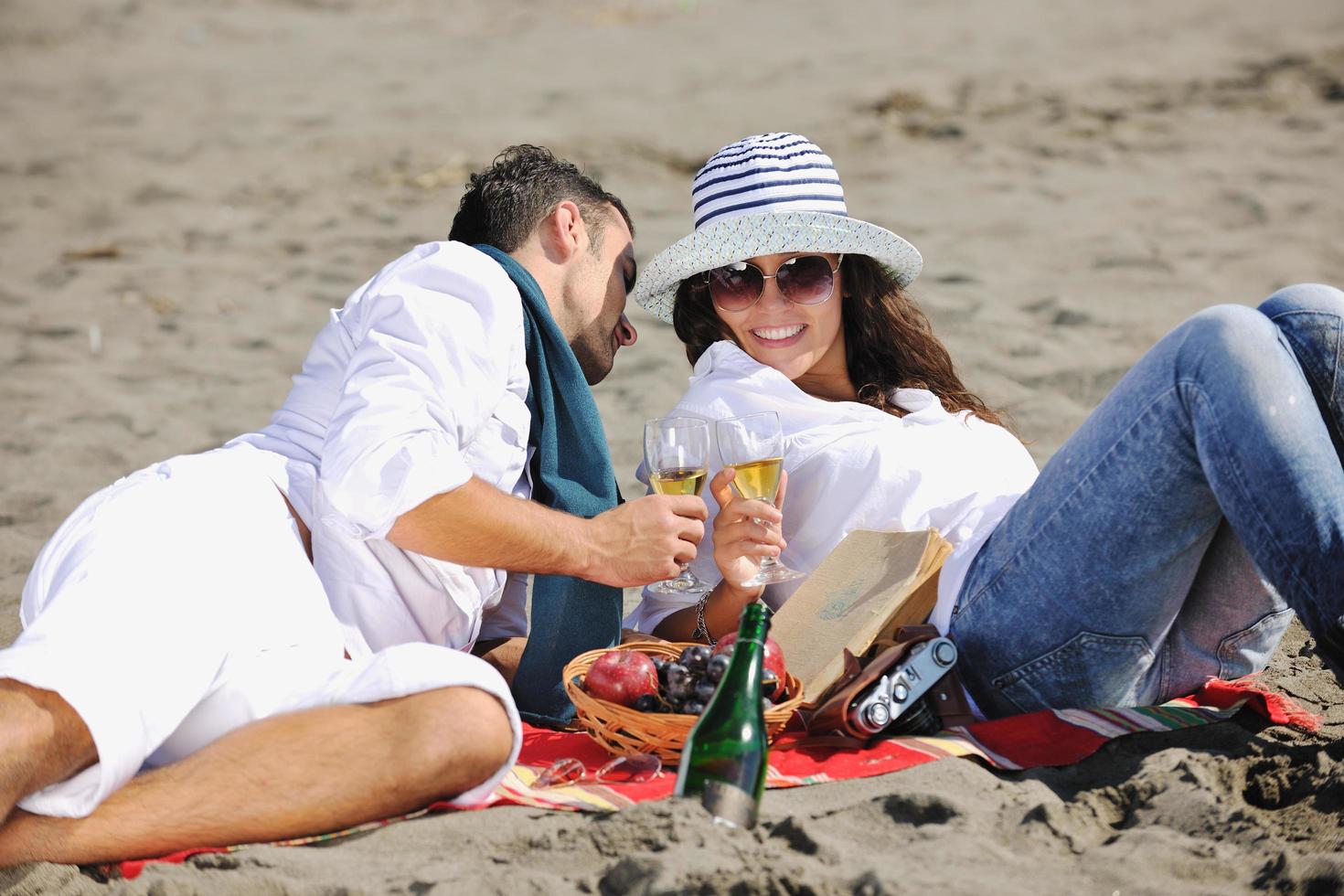 jong paar genieten van picknick Aan de strand foto