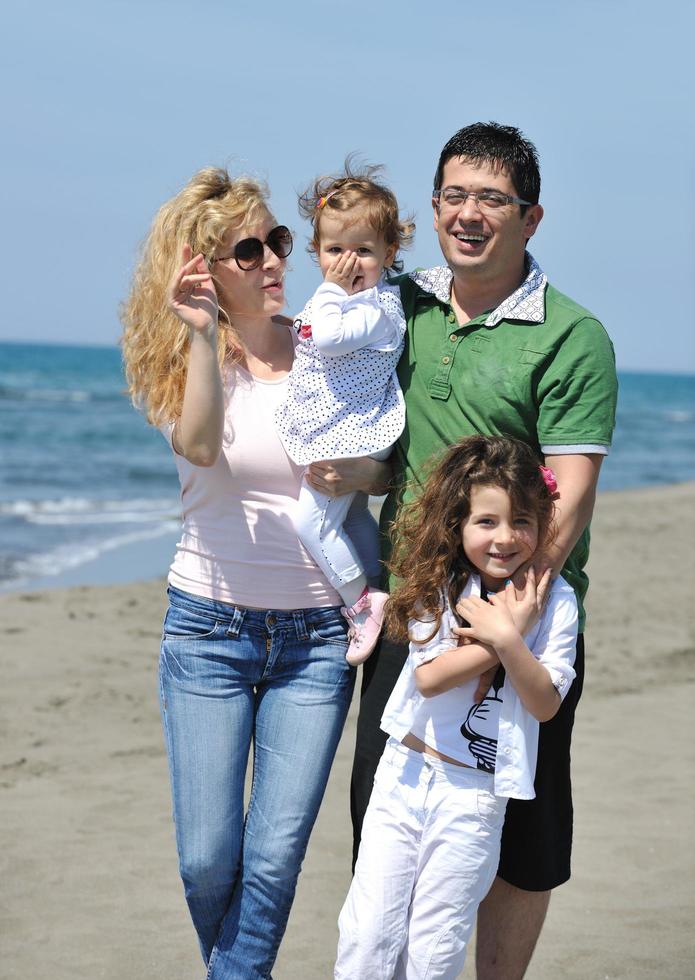 gelukkig jong familie hebben pret Aan strand foto