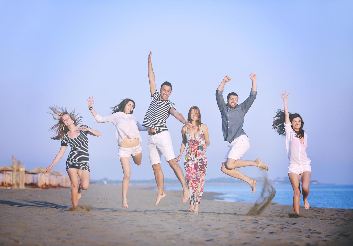 gelukkig jong mensen groep hebben pret Aan strand foto