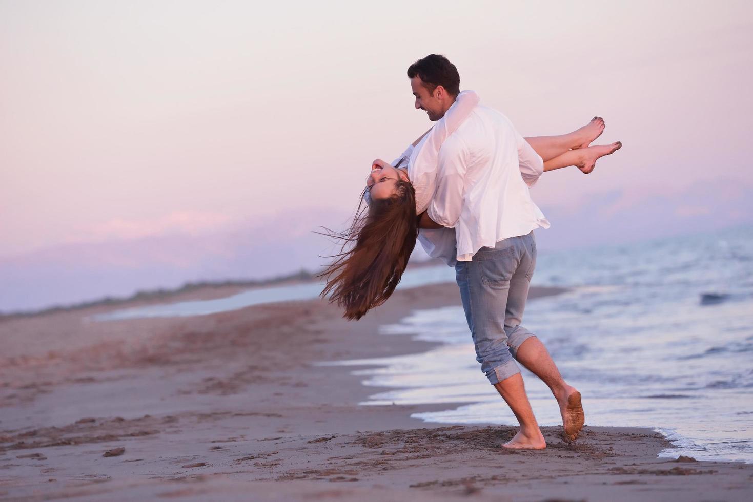 jong paar Aan strand hebben pret foto