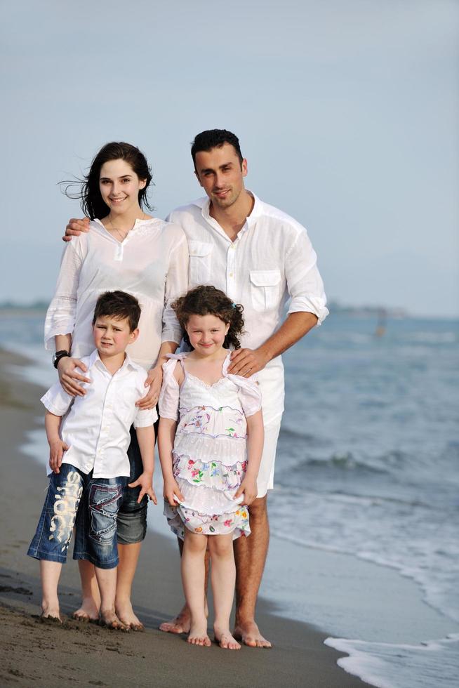 gelukkig jong familie hebben pret Aan strand foto