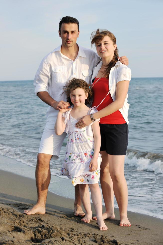 gelukkig jong familie hebben pret Aan strand foto