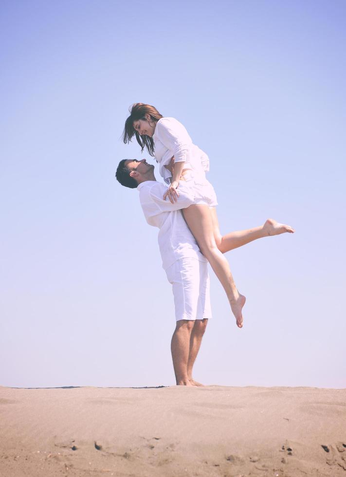 gelukkig jong koppel veel plezier op het strand foto