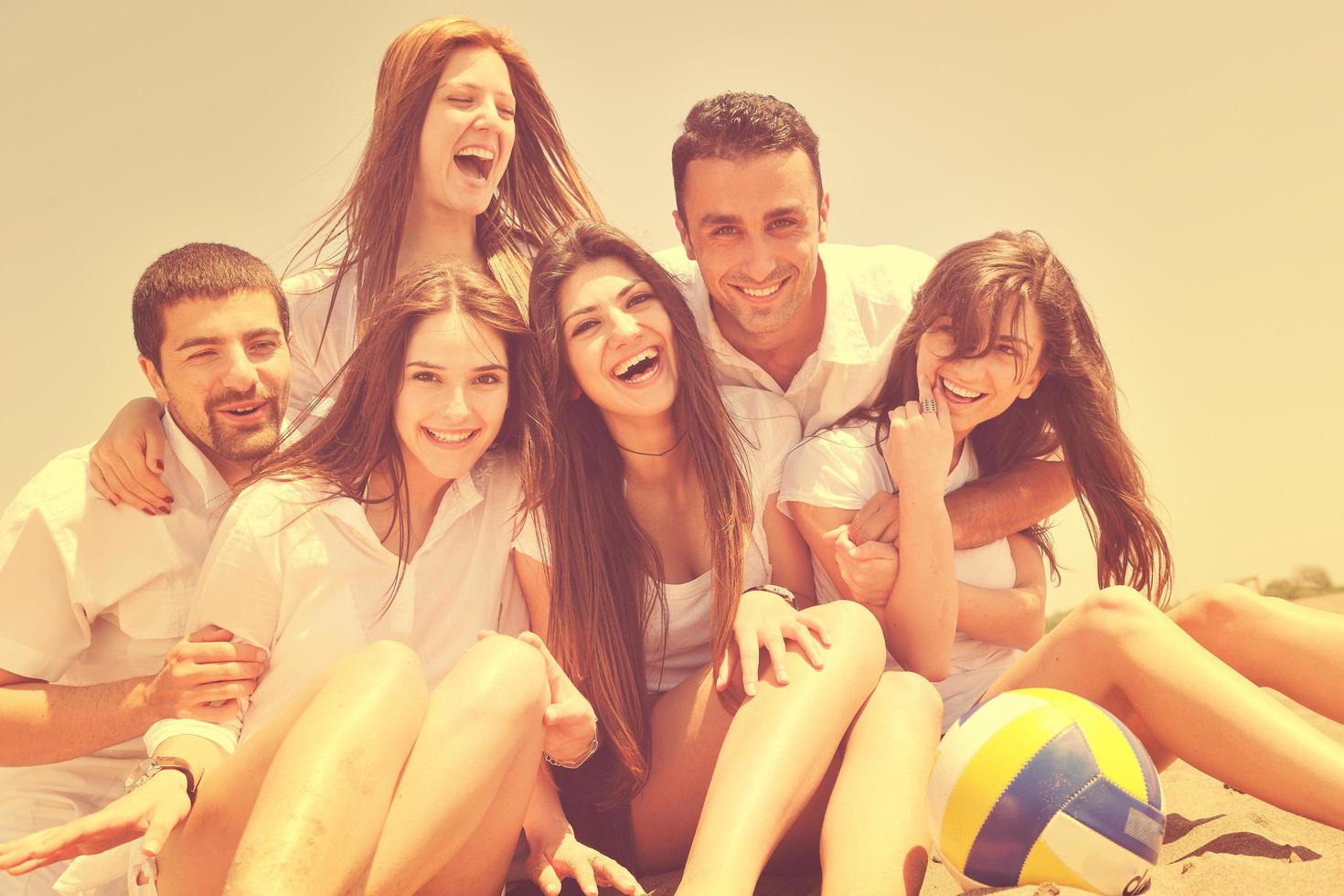 groep van gelukkig jong mensen in hebben pret Bij strand foto