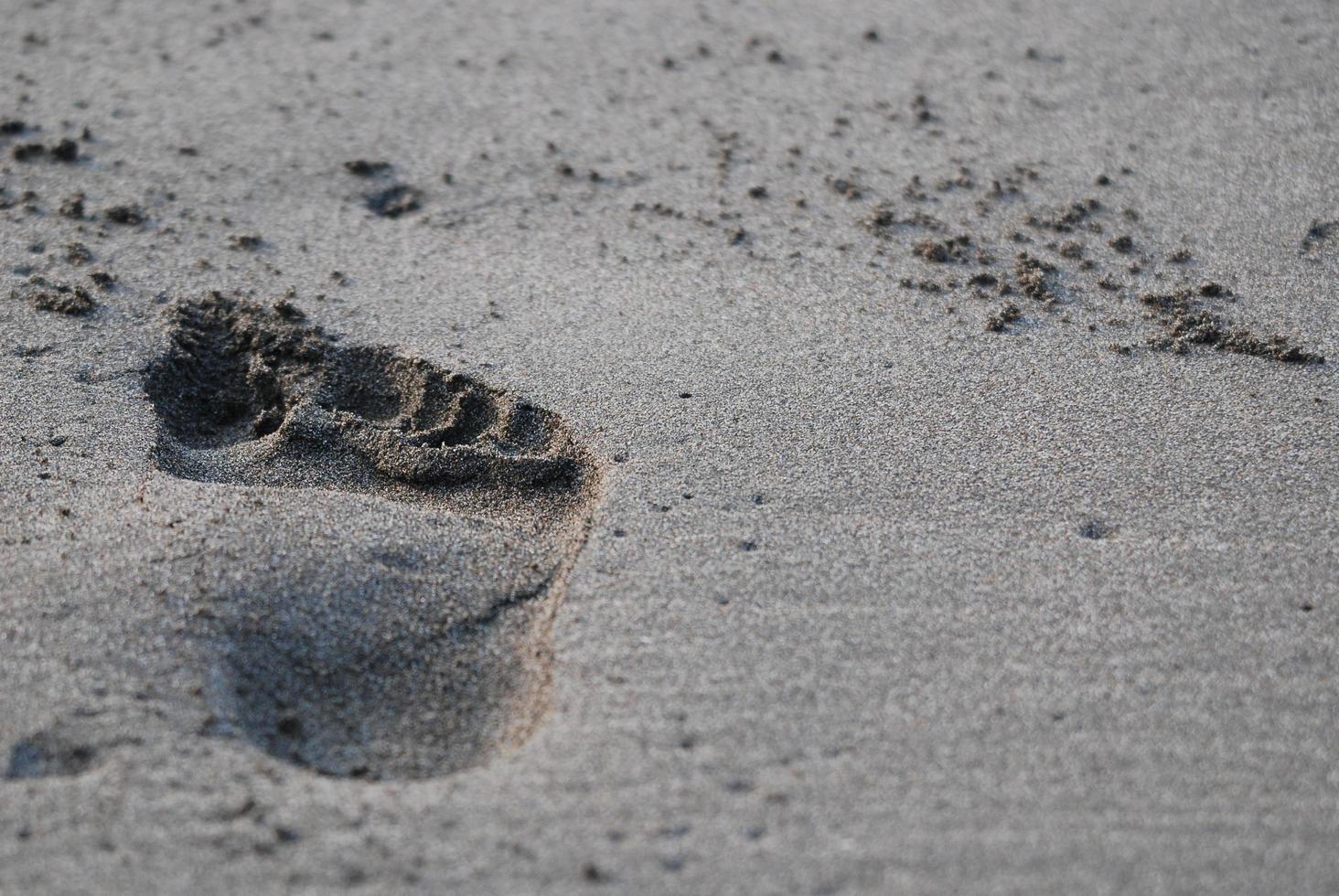 Rechtsaf voetafdruk Aan zand foto