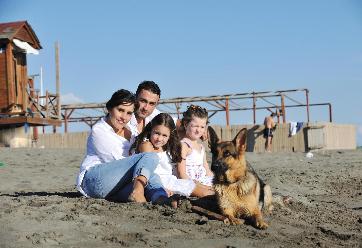 gelukkig familie spelen met hond Aan strand foto