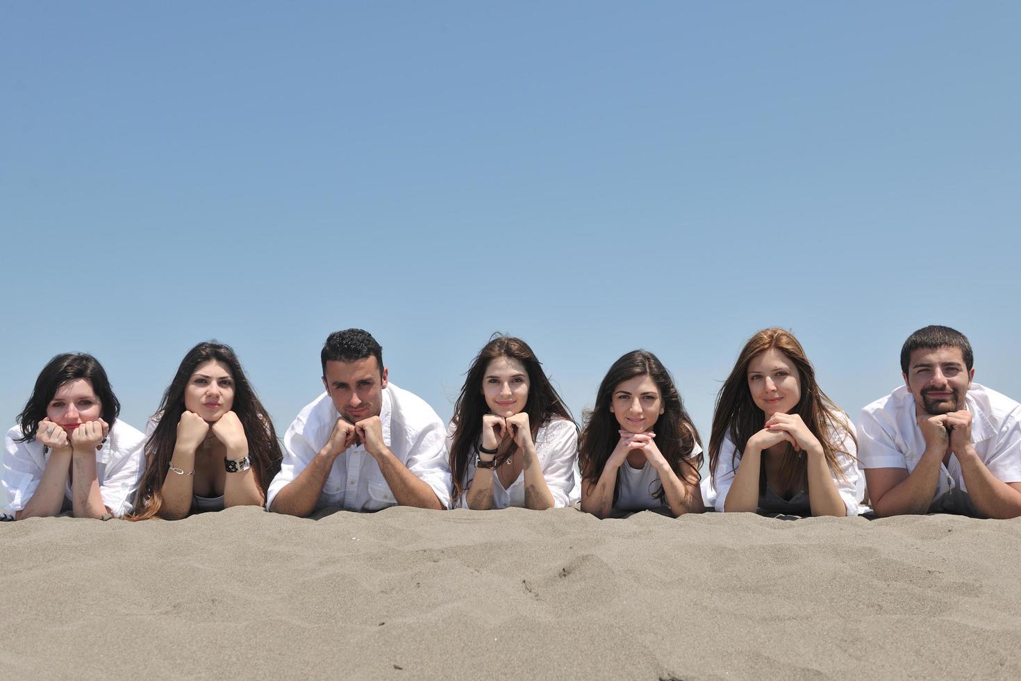 groep van gelukkig jong mensen in hebben pret Bij strand foto