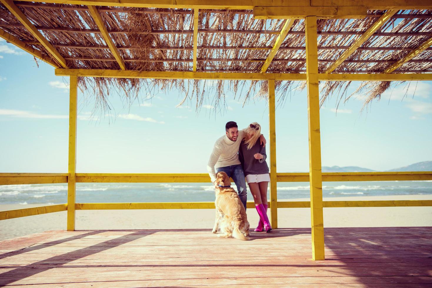 paar met hond genieten van tijd Aan strand foto