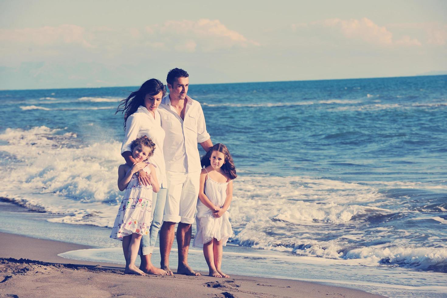 gelukkig jong familie hebben pret Aan strand foto