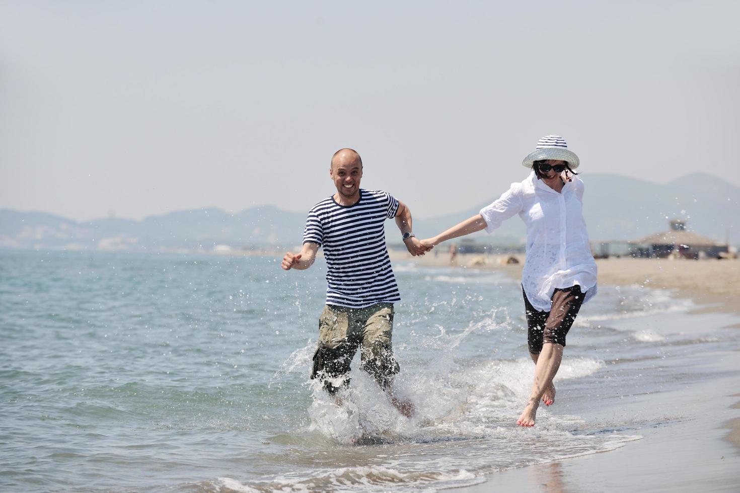 gelukkig jong koppel veel plezier op het strand foto