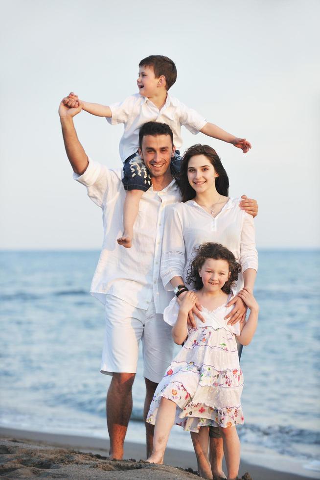 gelukkig jong familie hebben pret Aan strand foto