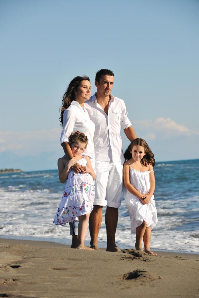 gelukkig jong familie hebben pret Aan strand foto