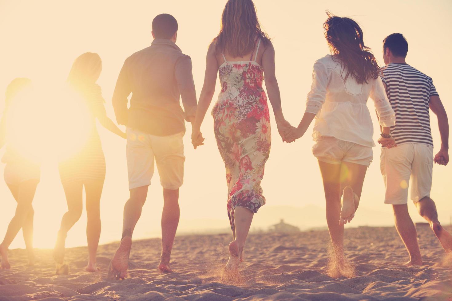 gelukkig jong mensen groep hebben pret Aan strand foto