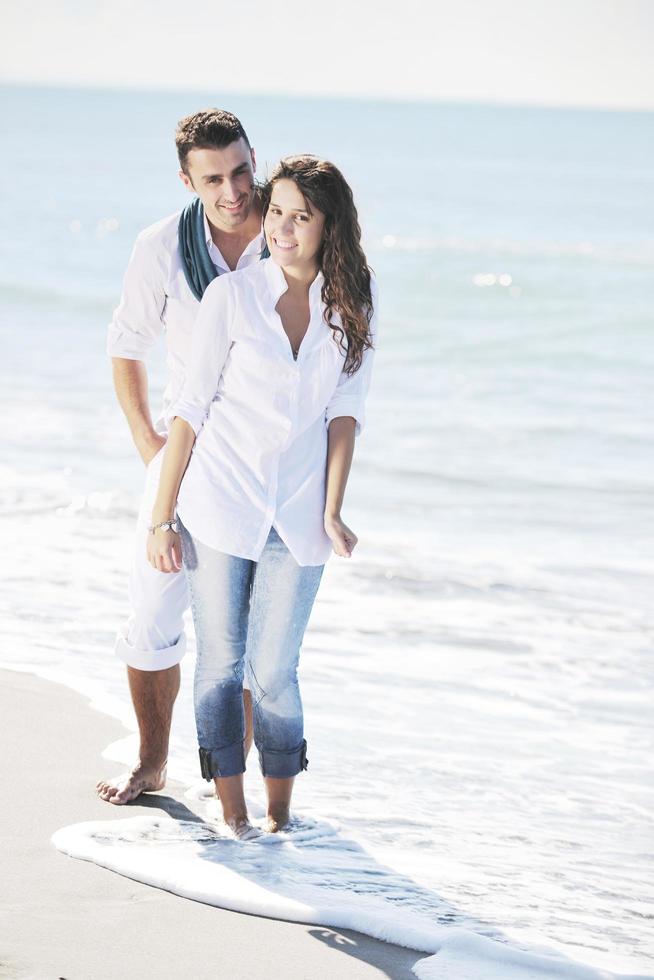 gelukkig jong paar hebben pret Bij mooi strand foto