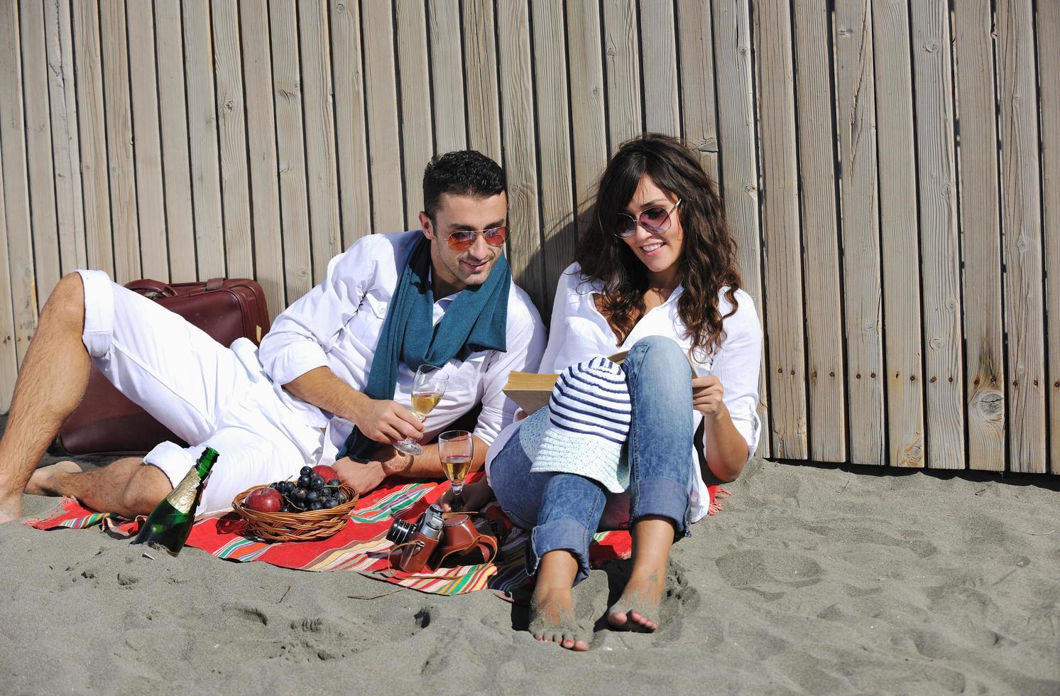 jong paar genieten van picknick Aan de strand foto