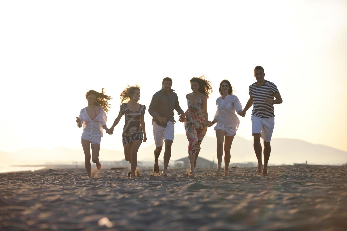 gelukkig jong mensen groep hebben pret Aan strand foto