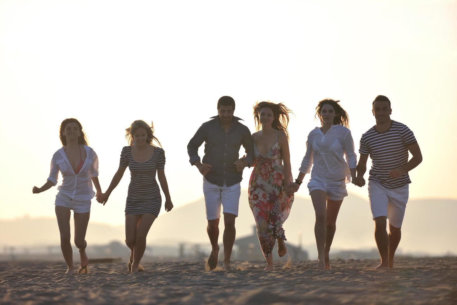 gelukkig jong mensen groep hebben pret Aan strand foto