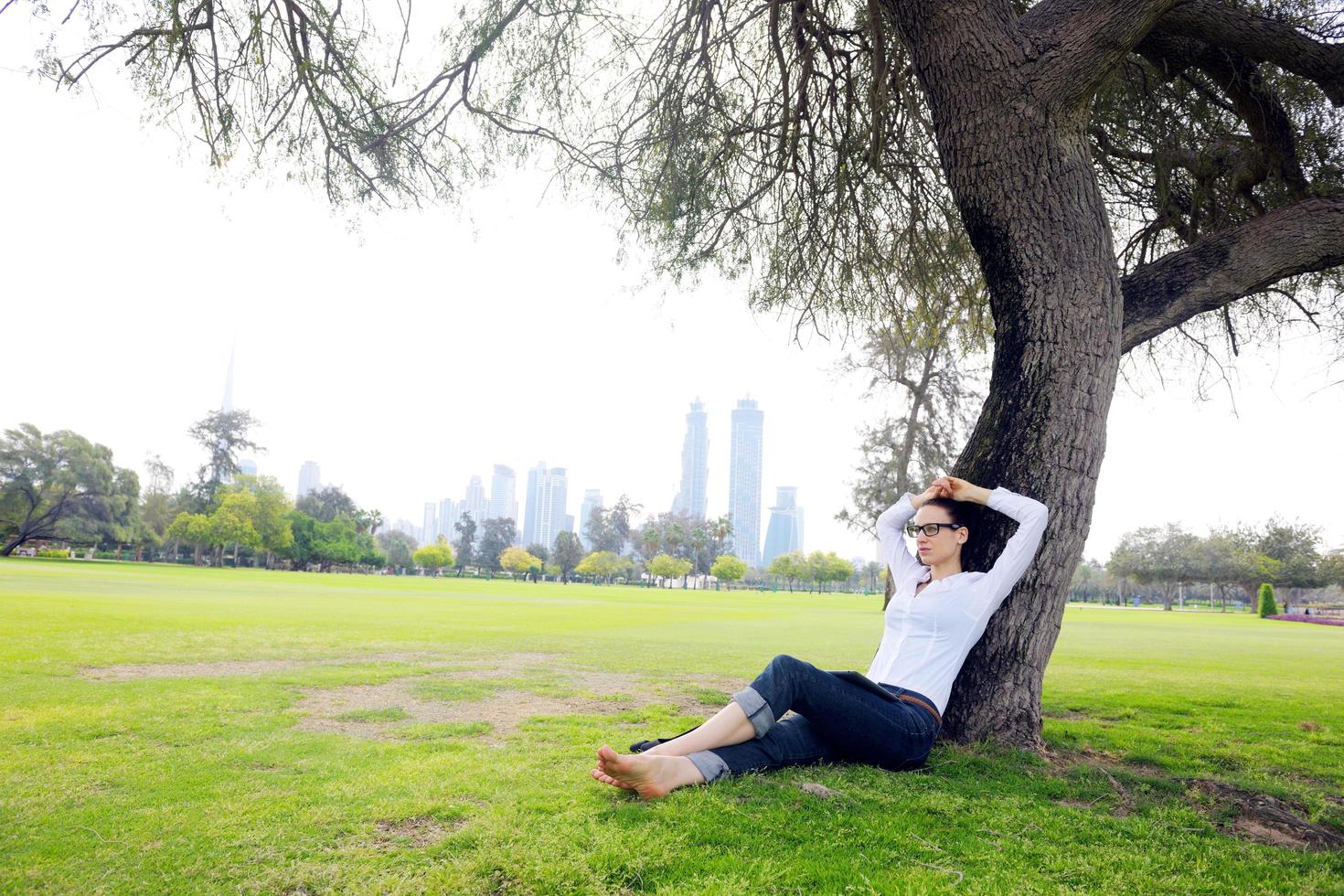 mooi jong vrouw met tablet in park foto