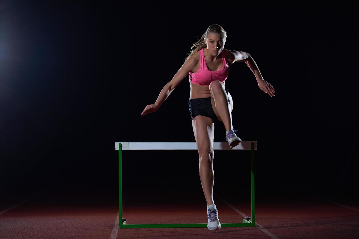 vrouw atleet jumping over- een hindernissen foto