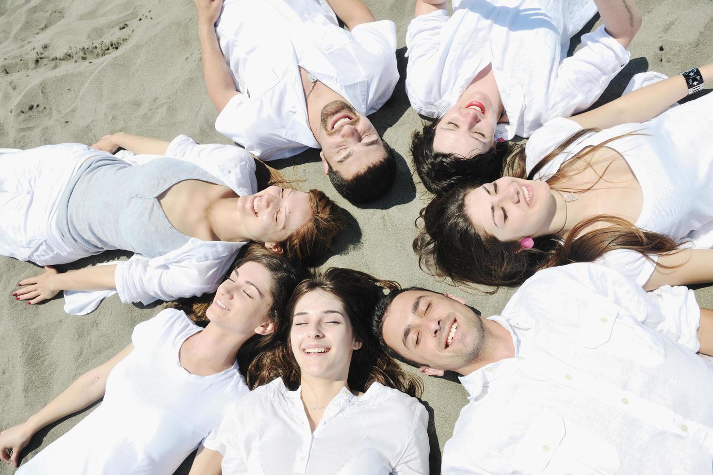 groep van gelukkig jong mensen in hebben pret Bij strand foto