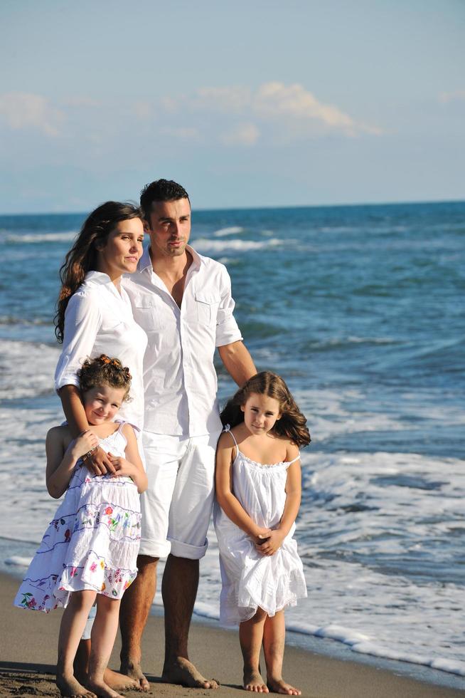 gelukkig jong familie hebben pret Aan strand foto