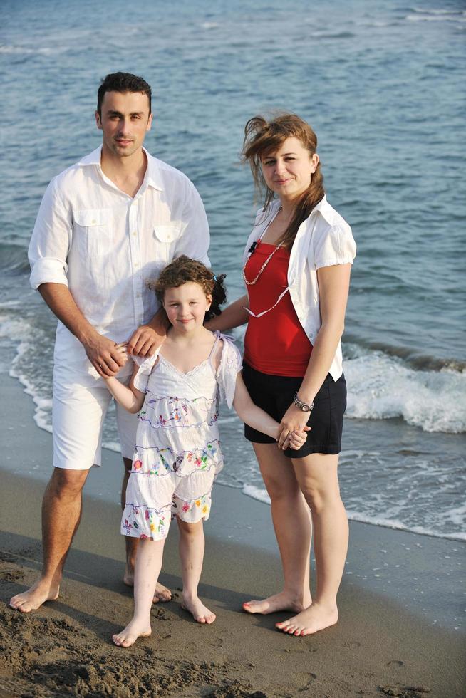 gelukkig jong familie hebben pret Aan strand foto