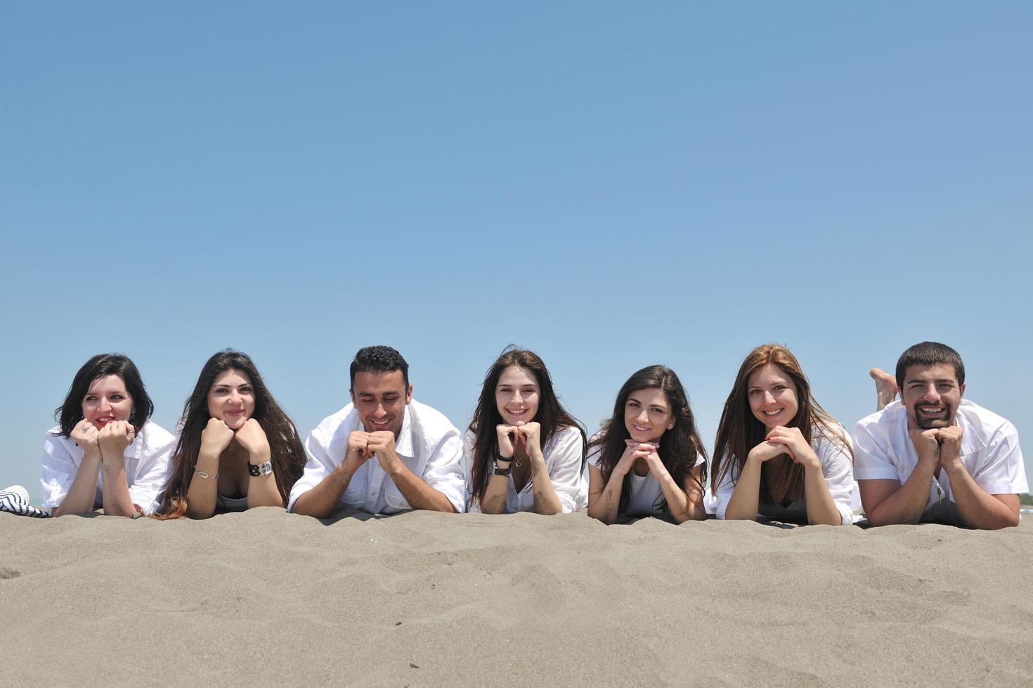 groep van gelukkig jong mensen in hebben pret Bij strand foto